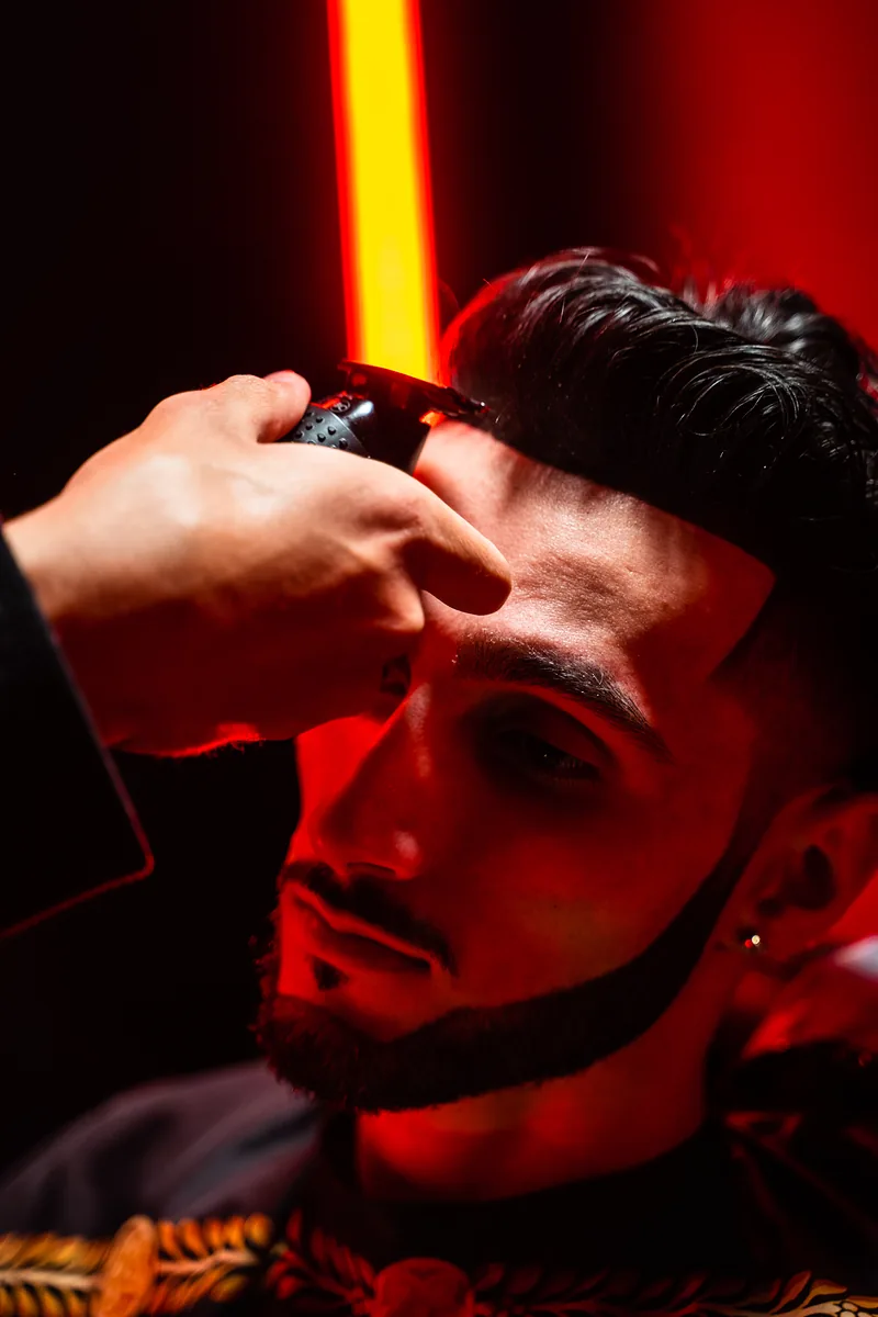 Close-up of a fade being detailed under red light